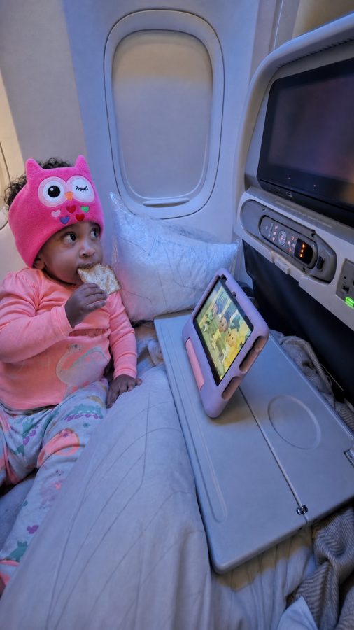 Toddler in a pink owl Snugsy Buds band on a flight