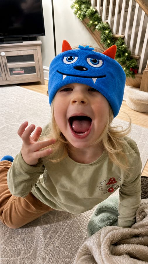 Happy child in a Snugsy Buds monster band at home